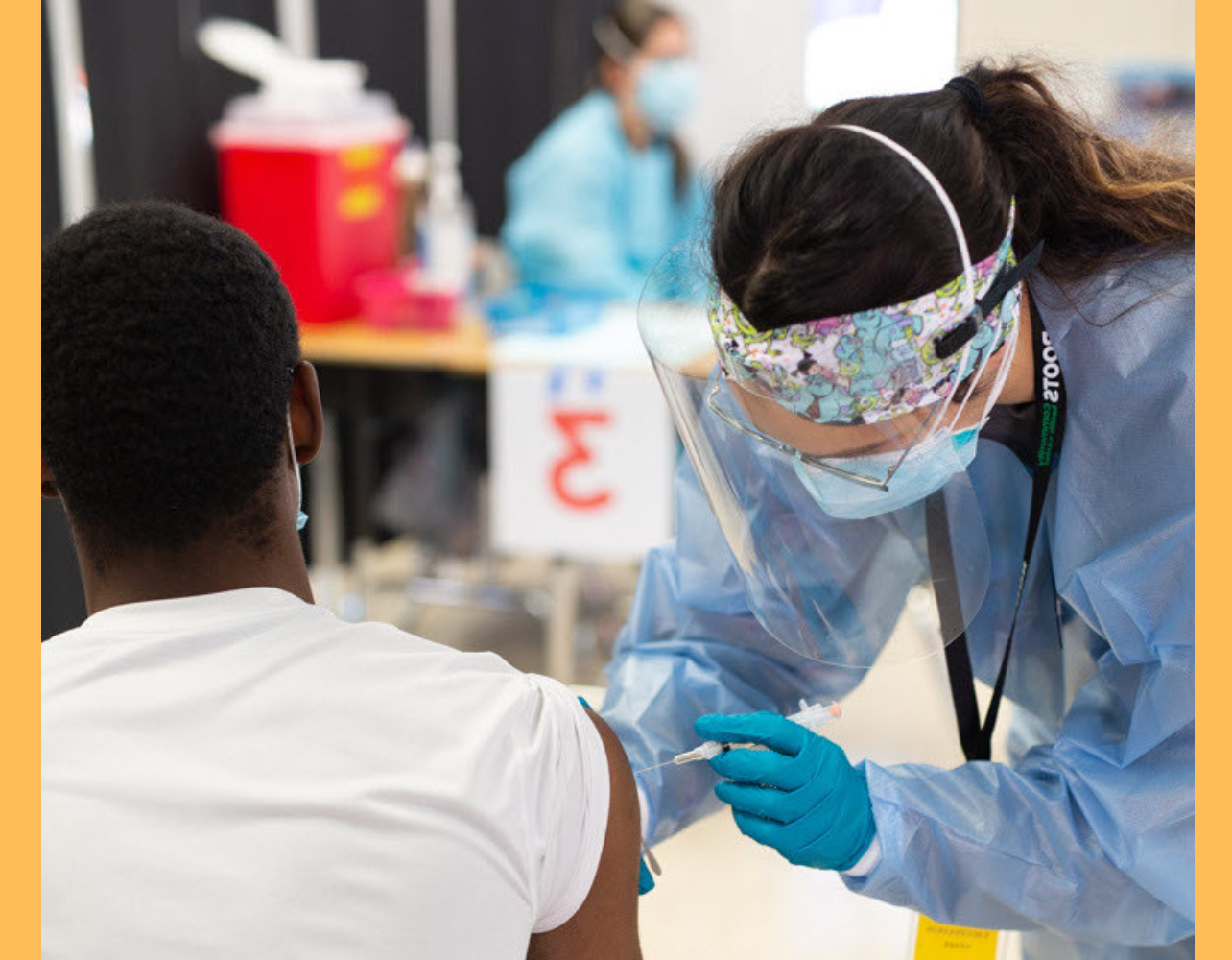 A student, wearing PPE, works in a community health clinic.